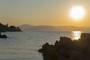 Sunset over the sea, silhouettes of rocks and mountains