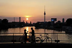Sunset over the Spree river, couple on the Oberbaum Bridge