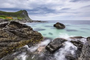Surf on rocky coast, sandy beach