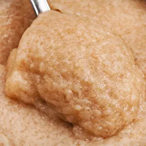 Surface of salty caviar of saffron cod with spoon close up