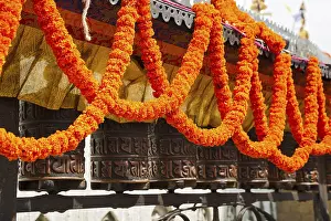 Swayambhunath. Prayer wheel, decorated with garlands of flowers
