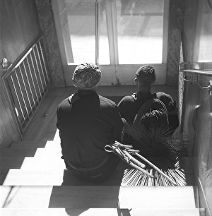 Sweepers in 1940. Two chimney sweeps are resting on the stairs in a doorway, perhaps chosen because it is a cooler place to sit and take a break than on the hot rooftop on this hot summer day in June 1940. Kristoffersson ref 154-8