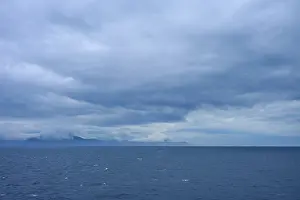 Sweeping views of the sea and distant clouds over the mountains on the horizon