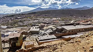 Sweeping views of a valley surrounded by mountains and scattered buildings