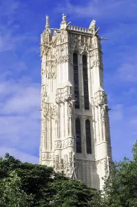 A tall Gothic tower rises against a blue sky