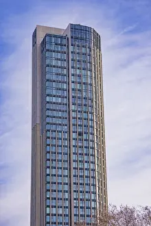 Tall modern skyscraper with many windows against blue sky