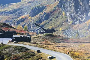 Framed Print : Tanks on a road through colorful autumnal hills in front of rocky mountains