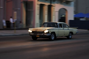 Taxi, American vintage car driving on the Malecon at twilight