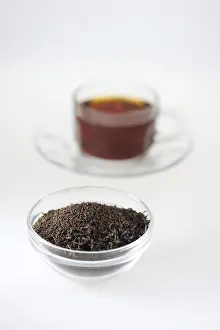 Tea dust in pot with tea cup on white background