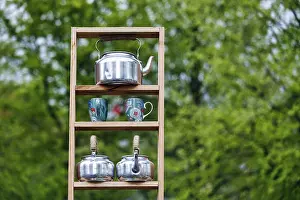 Tea kettle, kettle and tea cup on a shelf