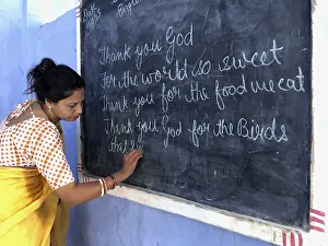Teacher writing with chalk on the blackboard