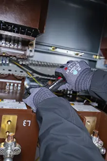 Category Historic EN Prints: A technician uses tools for maintenance work inside a switch box