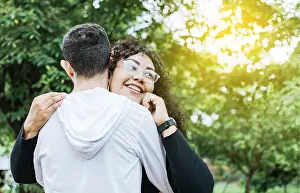 Teenage couple hugging outdoors