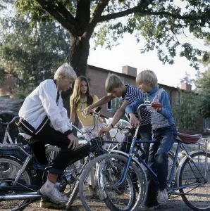 Teenagers in the 1960s. Four teenagers on the school yard after school. The moped is a Puch model Kansas. Sweden 1969