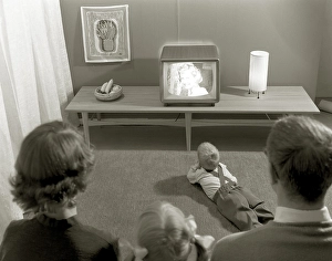 Television in the 1950s. A young couple is pictured in front of a typical 50s television set
