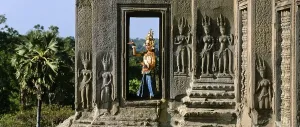 Category Buddhism Prints: Temple dancer or apsara in a window of the temple of Angkor Wat beside apsara reliefs