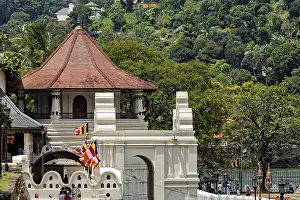 A temple with a pavilion surrounded by colorful flags and a river in the background