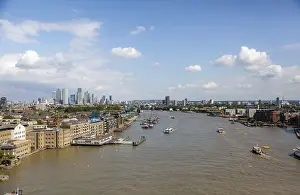 Thames River with visible boats and surrounding London architecture under a bright sky in London