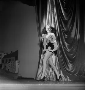 At the theatre 1951. A young woman holds a sign with the number thirteen in her hands on a theatre stage. It was common that beautiful girls paraded on stage between stage acts holding numbers marking the next act in the show