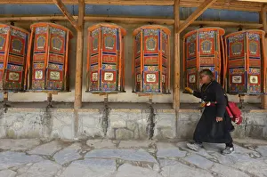 Tibetan Buddhism, elderly Tibetan woman in a traditional chuba during the morning kora