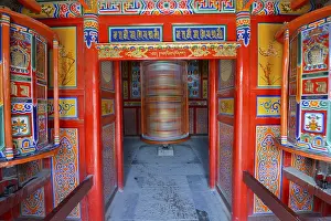 Tibetan Buddhism, a wooden prayer mill painted with symbols of Buddhism