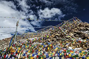 Tibetan prayer flags of Buddhism with Buddhist mantra on it on top of Himalayan pass Khardung La