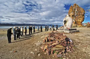 Tibetians at the sacrifice hearth next to the Stone Couple with prayer flags