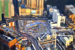 Tilt shift blur effect. Amazing aerial cityscape view with crane working at building construction