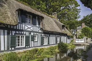 Timber-framed house with thatched roof along the river Veules