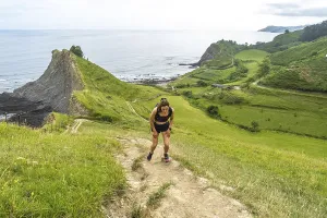 Tired athlete taking a break during trail running workout along the picturesque cliffs of zumaia