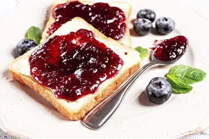 Toast with blueberry jam, on a white plate