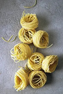 Togliatelle pasta on gray background, copy space