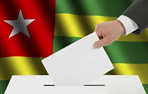 The Togo flag and the hand with the bulletin about the ballot box