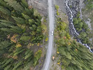Top-down, aerial view, car on road in forest
