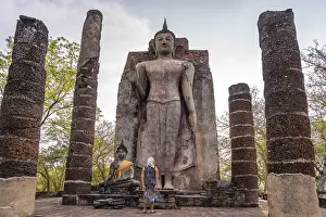 Category Buddhism Prints: Tourist in front of the giant standing Buddha in the temple Wat Saphan Hin