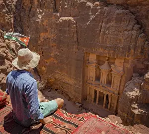 Tourist with sun hat sitting on carpet