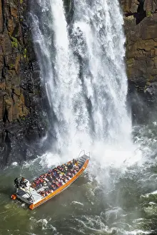 Tourists in a boat, at the foot of the Iguazu Falls