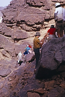 Tourists clambering down rocks visiting prehistoric sites, Tassili N'Ajjer National Park, Algeria, north Africa 1973, Africa