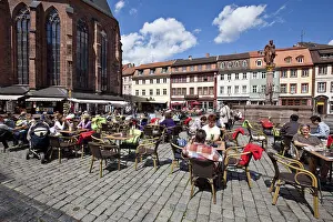 Tourists enjoying the sunshine in the old market square with the Herkulesbrunnen