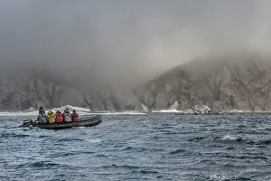 Tourists in an inflatable boat approaching Herald Island