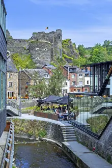 Tourists at restaurant along the river Ourthe and ruined castle in the city La Roche-en-Ardenne