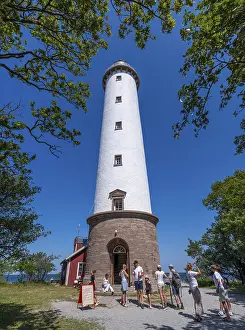 Tourists stand in front of the Lange Erik lighthouse