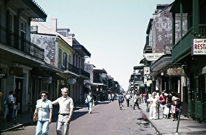 Tourists walk down the street, past bars, Bourbon Street, French Quarter, New Orleans, Louisiana, USA 1976