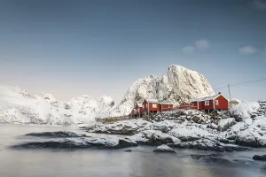 Town and fisherman's cabins or Rorbus in front of snowy mountains