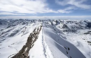Tracks in the snow on a narrow mountain ridge in winter