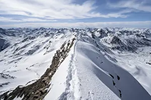 Tracks in the snow on a narrow mountain ridge in winter
