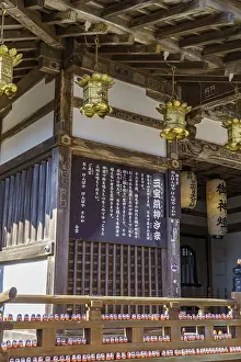 Traditional Japanese temple with wooden details and lanterns on the walls