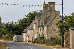 A traditional stone house on a rural road with festive garlands