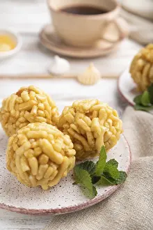 Traditional Tatar candy chak-chak made of dough and honey with cup of coffee on a white wooden background