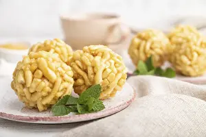 Traditional Tatar candy chak-chak made of dough and honey with cup of coffee on a white wooden background